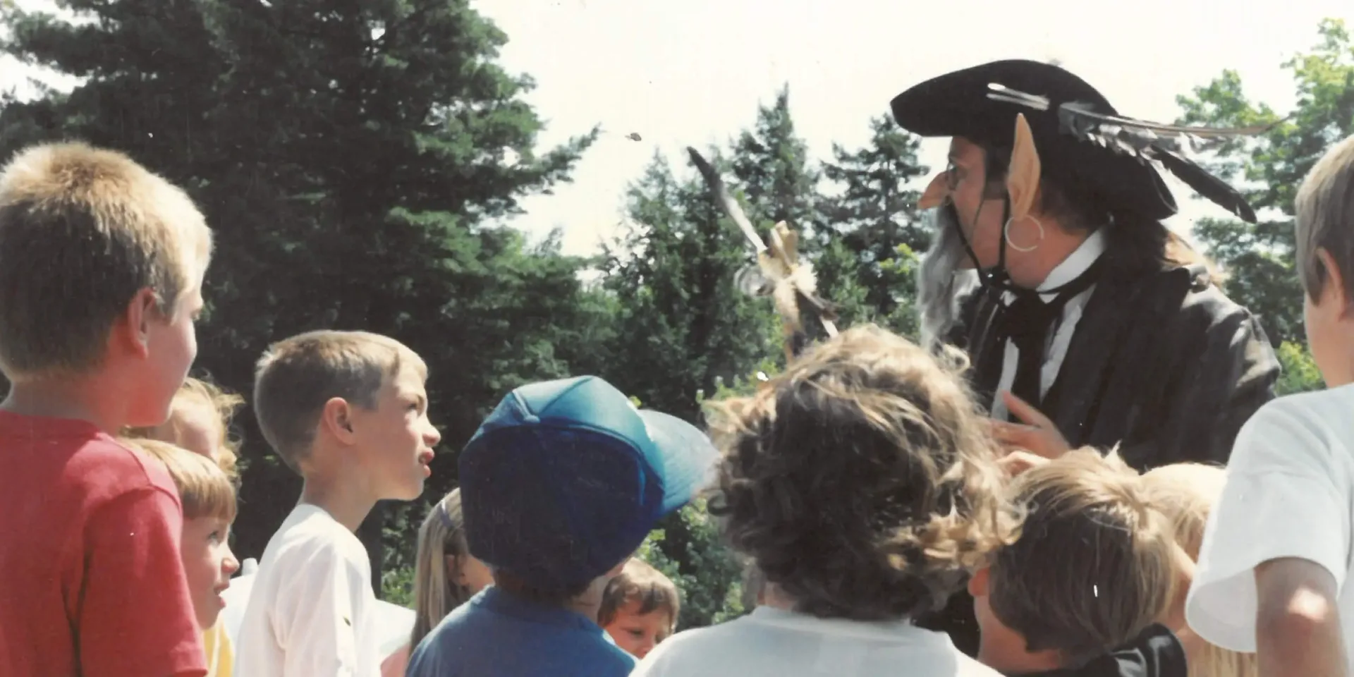 Man in pirate costume entertaining children outdoors