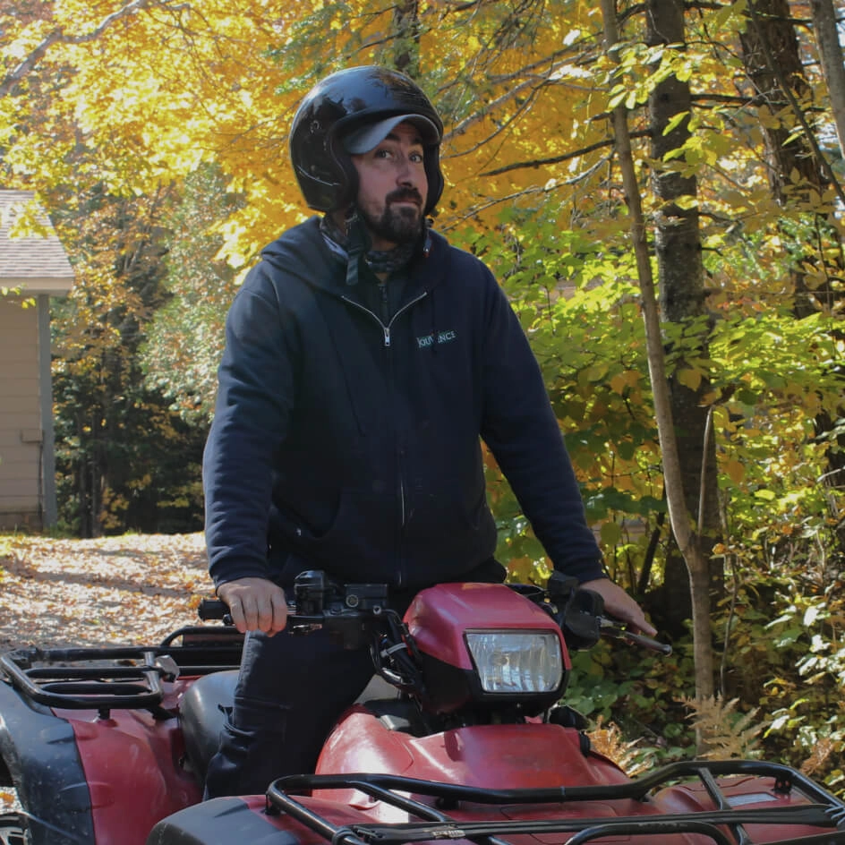 Homme en casque sur quad rouge en automne